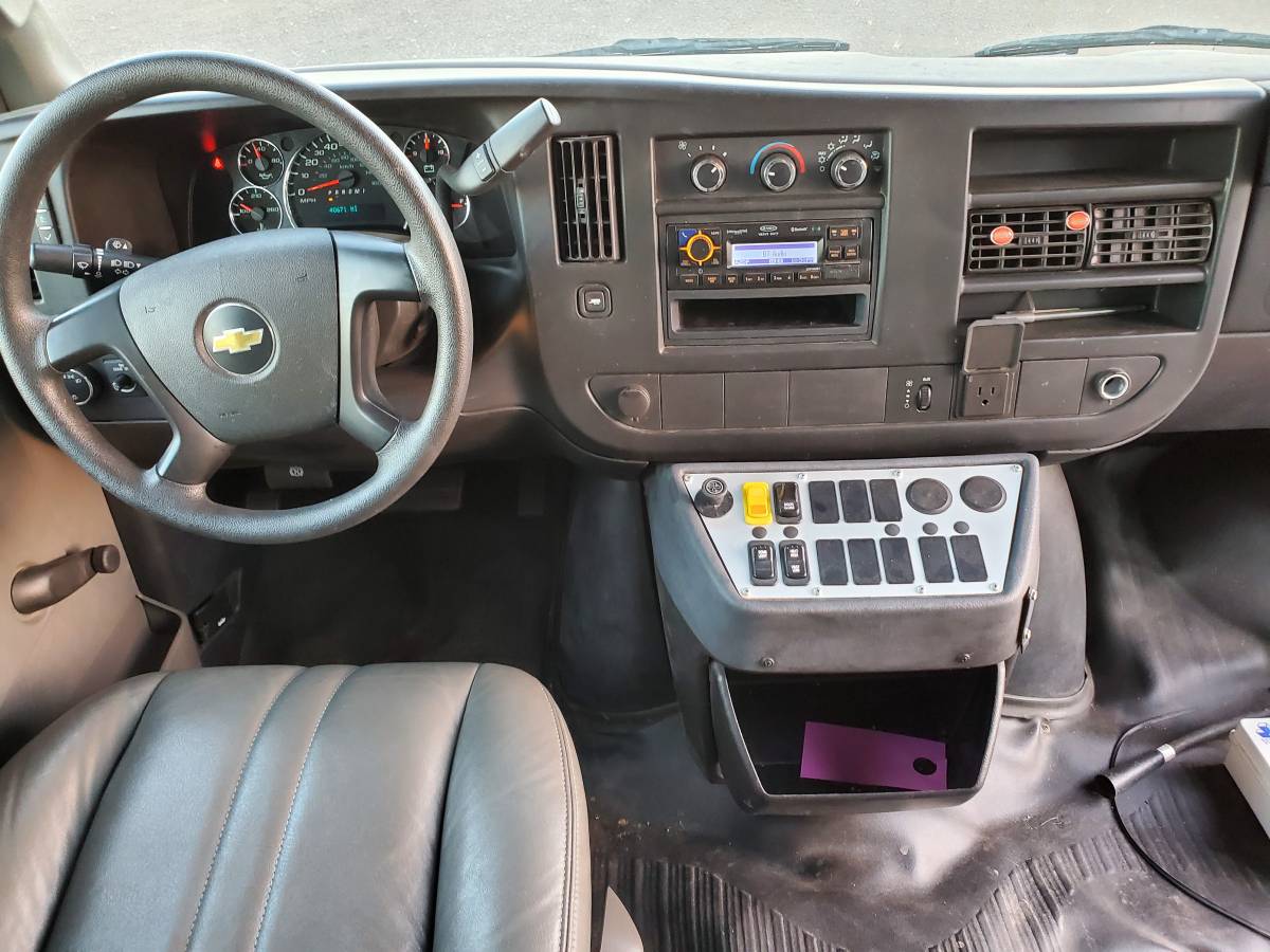 RV rental driver's area: steering wheel, dashboard, radio, HVAC, and auxiliary switches for various functions. — photo 2