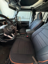 Inside a Jeep: black/orange custom seats, steering wheel, and dash visible. Consider this robust option for your rv rental needs.