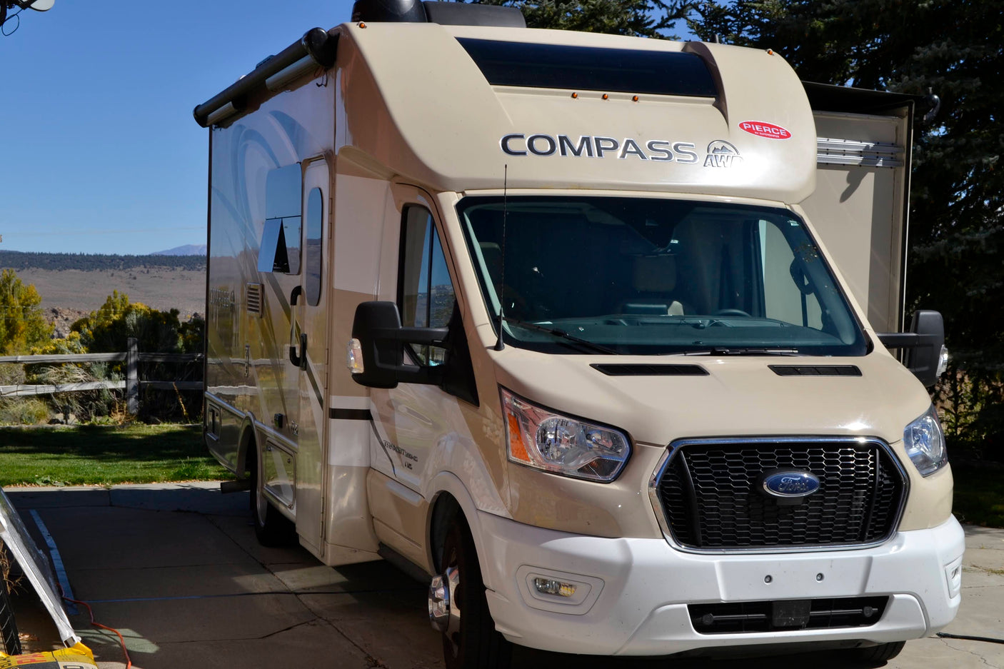 Beige Ford Transit-based Compass AWD RV rental parked outdoors, ready for adventure.