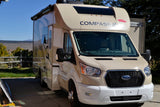 Beige Ford Transit-based Compass AWD RV rental parked outdoors, ready for adventure.