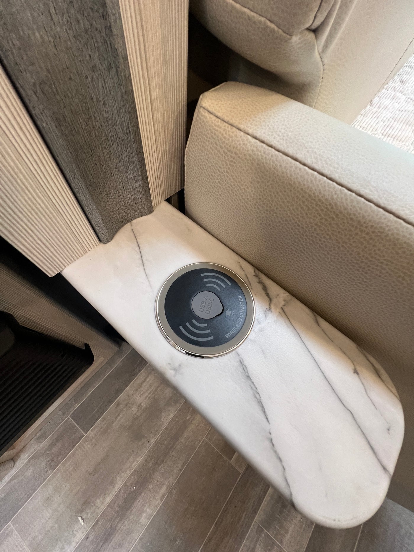 Modern RV rental interior: Wireless charger with USB-A/C ports integrated into a marble-look counter by seating. — photo 20