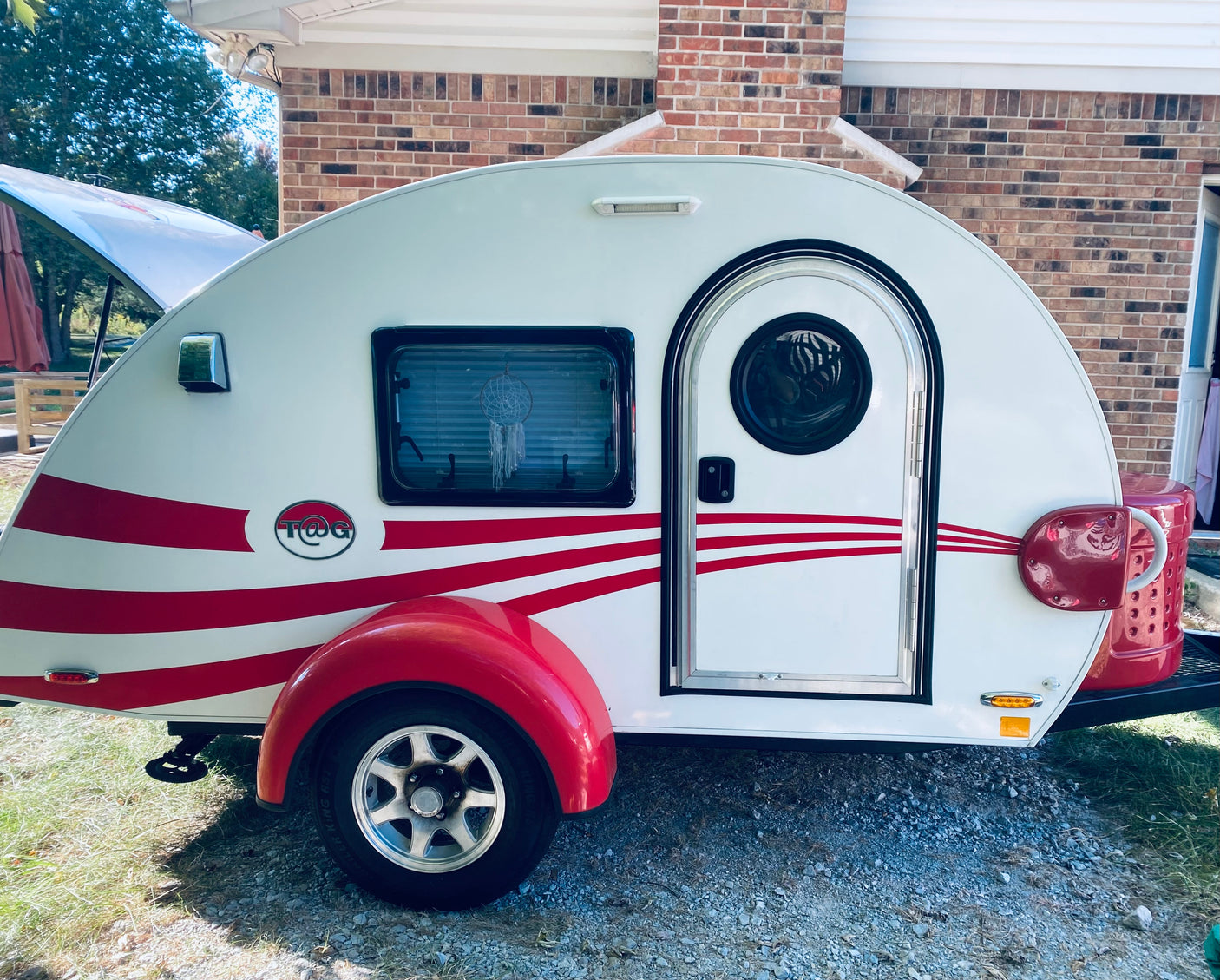 Ready for adventure! A bright white & red teardrop camper, perfect for an rv rental or compact camping trips.