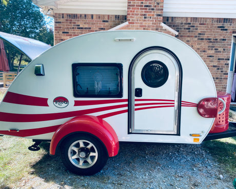 Ready for adventure! A bright white & red teardrop camper, perfect for an rv rental or compact camping trips.