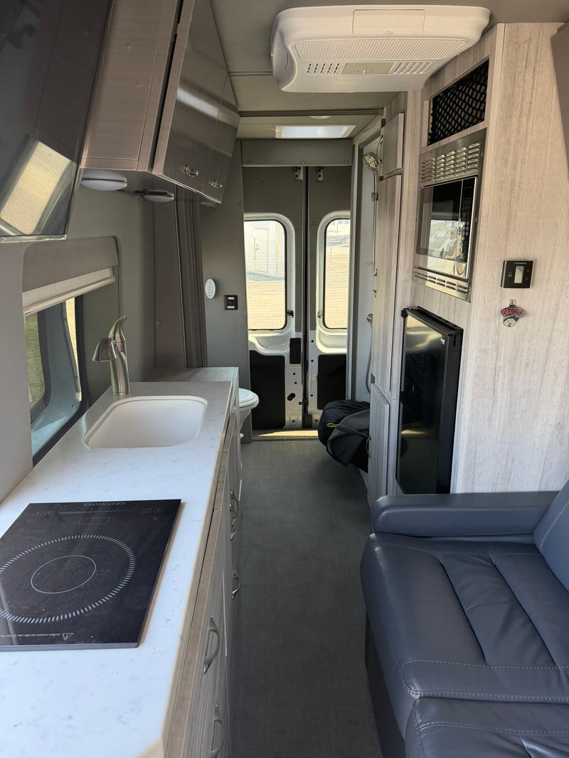  offering spacious comfort.|Spacious RV rental interior featuring a comfortable gray leather sofa — photo 6