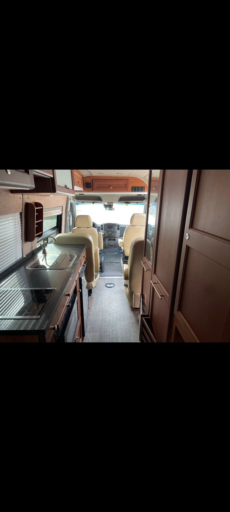 RV rental interior: Modern camper van with kitchen, beige captain seats, and driver's cabin. — photo 5