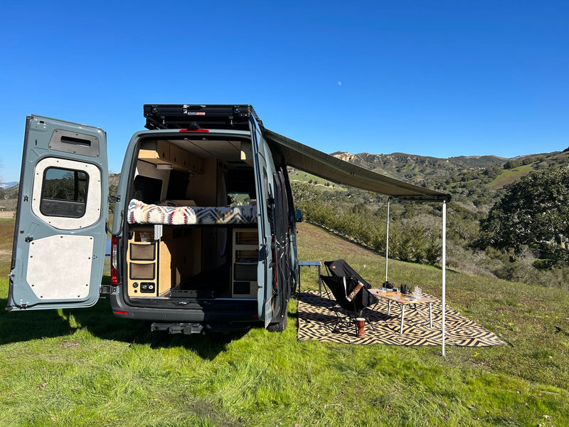  shows a cozy bed & convenient pull-out storage.|This RV rental offers a functional interior with swivel chairs — photo 10