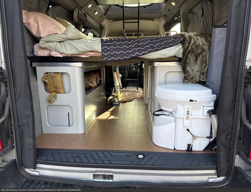 Cozy camper van rv rental interior featuring a raised bed, under-bed storage, and a composting toilet for comfortable travels. — photo 16