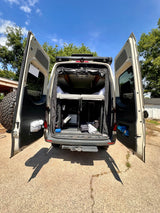 Explore this open RV rental camper van with a cozy bed, ample gear storage, & a rooftop rack for adventures.