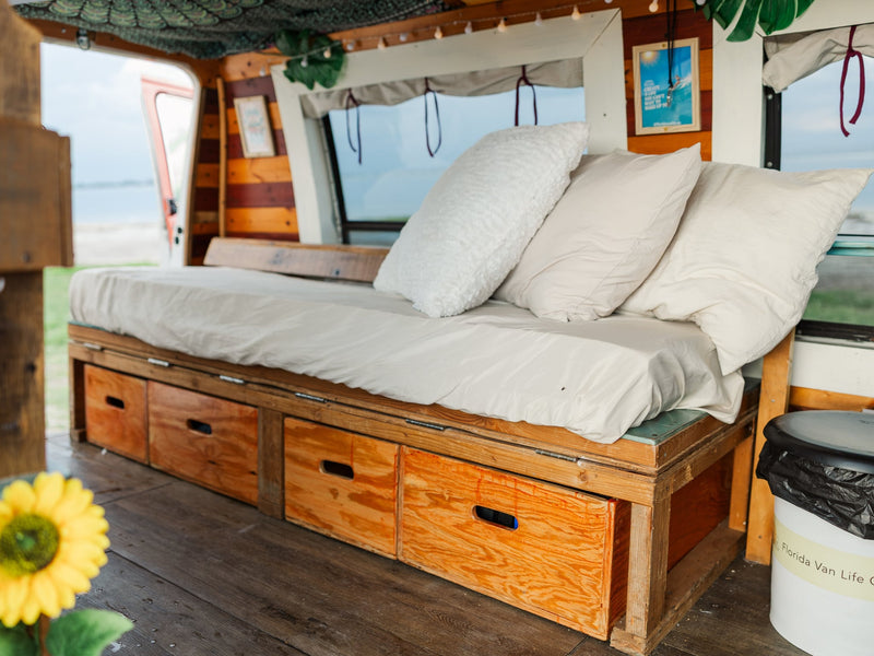  and a window view.|Step inside this cozy rv rental camper van: a charming interior with a bed — photo 17