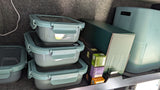 RV rental kitchen: Stacked meal prep containers, coffee pods, and a compact appliance neatly organized for travel.
