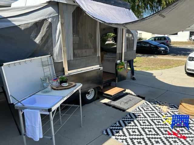 Cozy pop-up rv rental setup with outdoor kitchen, games, and inviting patio space. Perfect for your next adventure. — photo 7