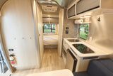 Explore this bright rv rental interior, highlighting its functional kitchen, cozy bedroom, and modern design with essential amenities.