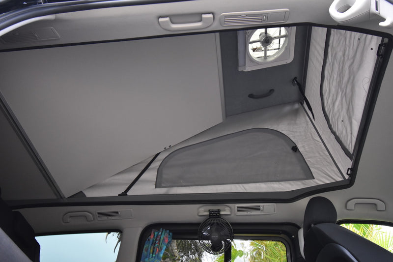RV rental interior showing a raised pop-top roof with mesh windows and ceiling fan, offering ample ventilation and sleeping space. — photo 18