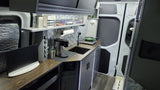 This modern RV rental interior features a sleek camper kitchen with sink, induction cooktop, coffee maker, and LED lighting.