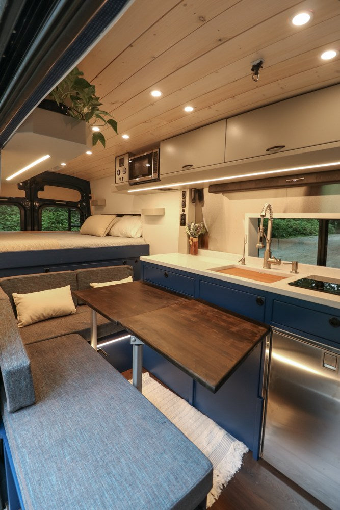  revealing its cozy interior.|This modern RV rental interior features a cozy bed — photo 2