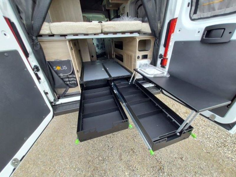  and overhead storage in a camper van.|View inside a modern RV rental featuring a bunk bed — photo 5