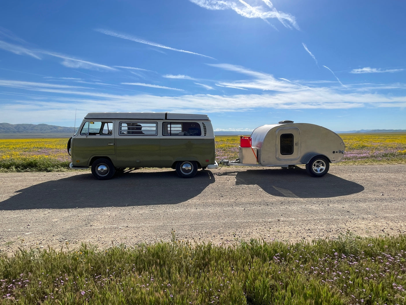 Vintage VW camper and teardrop RV rental enjoying wildflowers. Perfect for your next nature road trip!