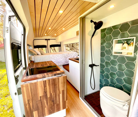 This RV rental offers a spacious interior: a wood kitchen counter, a cozy rear bed, and a tiled wet bath with a shower and toilet.