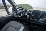RV rental camper van interior: driver's view of dashboard, steering wheel, and a sandy, foggy beach outside.