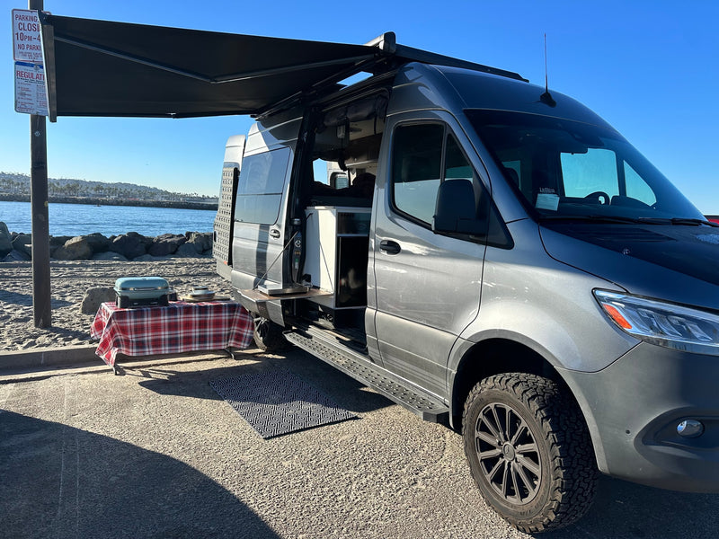 Gray rv rental van with awning deployed, featuring an outdoor kitchen and grill for beachside cooking and relaxation. — photo 6