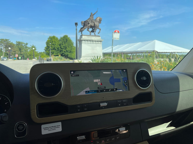Inside an RV rental: dashboard with navigation showing Forest Park, an equestrian statue, and a large tent visible outside. — photo 5