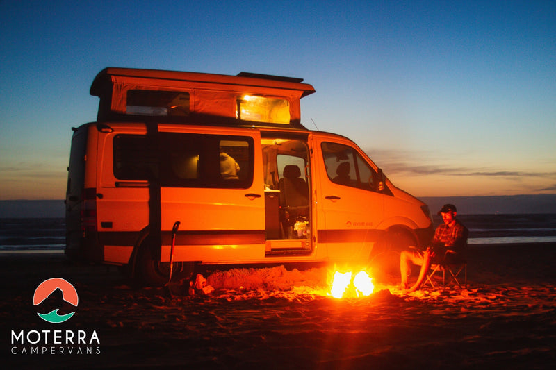  and comfy blankets. Ready for adventure!|Cozy RV rental interior: a bed with a red plaid comforter in a spacious pop-top campervan. Perfect for road trips.|Perfect RV rental adventure: a campervan on a sandy beach at dusk — photo 4