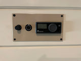 Beige control panel for an Eberspächer heater in an RV rental, showing a digital display, a large knob, and a small button.