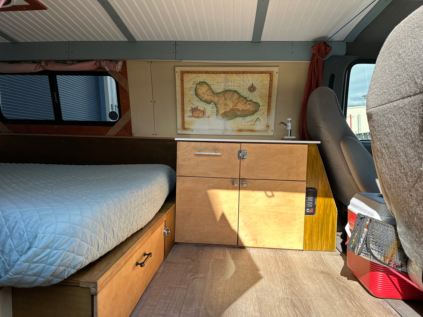 This RV rental offers a well-appointed camper van interior with a bed, built-in storage, and a practical kitchen area.