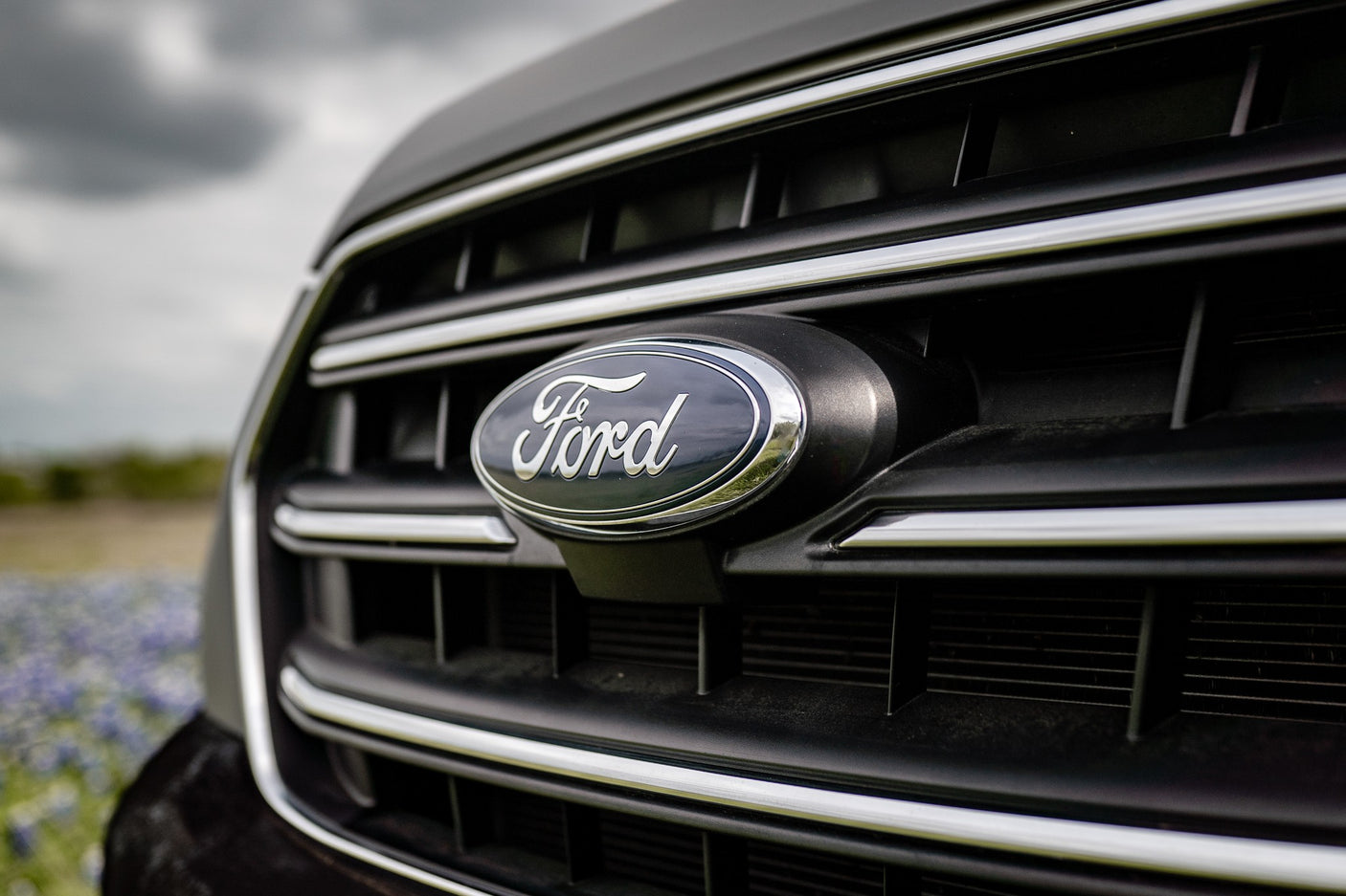 Detailed shot of a Ford vehicle's front grille and oval emblem, suggesting robust options for your next RV rental.