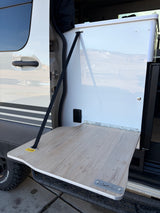 A handy fold-down table extends from this rv rental's side, supported by a strap, showing its 15 lbs capacity for outdoor use.