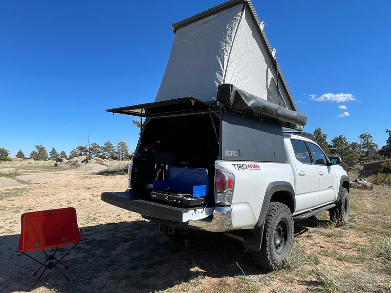 White Toyota Tacoma with Go Fast Camper and tailgate kitchen, ideal for an rv rental adventure in nature. — photo 8