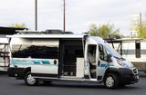 Silver Tellaro camper van with an open side door and extended awning, showcasing its interior for your next RV rental.