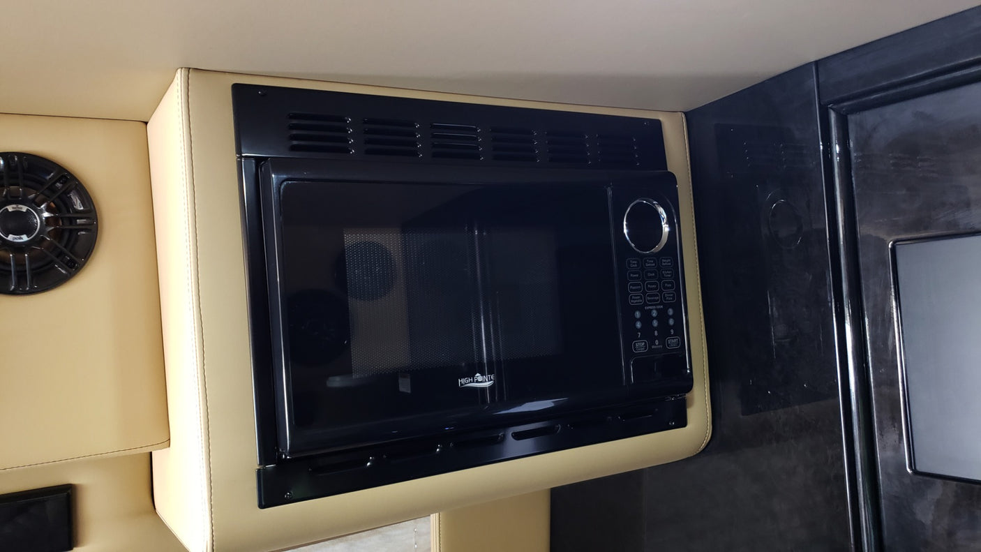 High Pointe microwave in a tan-upholstered RV rental interior, next to a Polk speaker. Convenient for your travels.