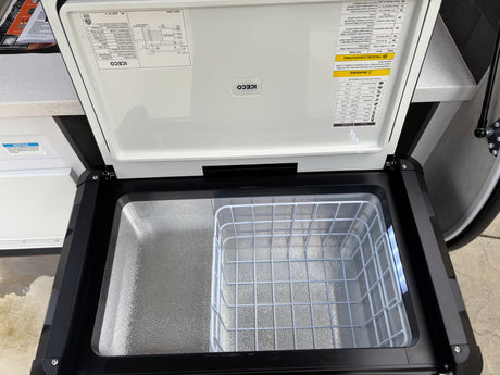 Open ICECO portable fridge/freezer for your rv rental. Interior shows a wire basket and product info on the lid.