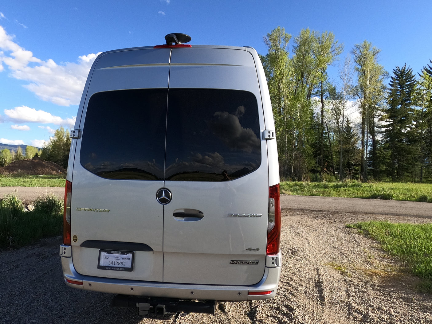 Rear view of a silver Mercedes Sprinter rv rental van from Lazydays, perfect for outdoor camping adventures.