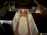 Cozy and compact RV rental interior at night, featuring a galley kitchen, bed, and soft ambient lighting.