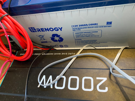 Close-up of a Renogy 12V battery and 2000W inverter, essential components for an rv rental power system.