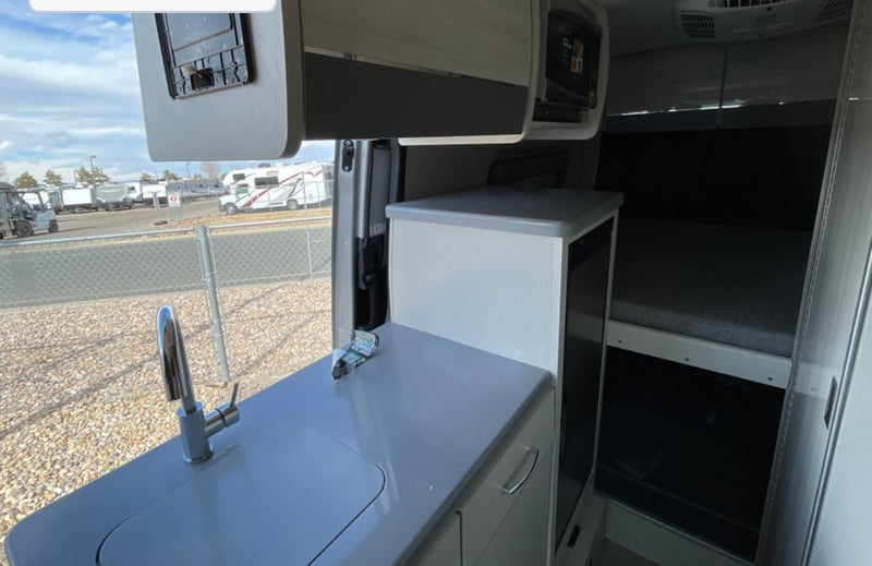  and swivel chairs.|Cozy RV rental bed with grey pillows — photo 9
