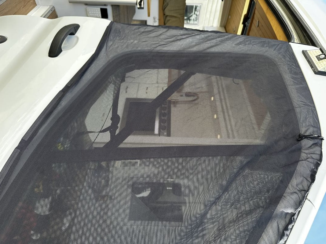 RV rental featuring a black mesh mosquito screen over an RV door or window for bug-free travel.
