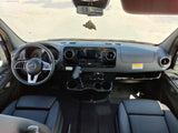 Step inside this modern Mercedes-Benz RV rental! View of the cockpit: steering wheel, large display, and front seats.