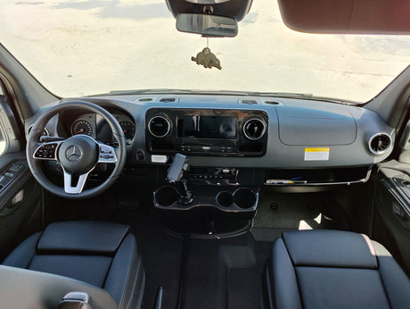 Step inside this modern Mercedes-Benz RV rental! View of the cockpit: steering wheel, large display, and front seats.