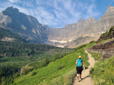 Discover majestic mountains & winding trails by RV rental! A hiker ascends a scenic path surrounded by lush greenery.