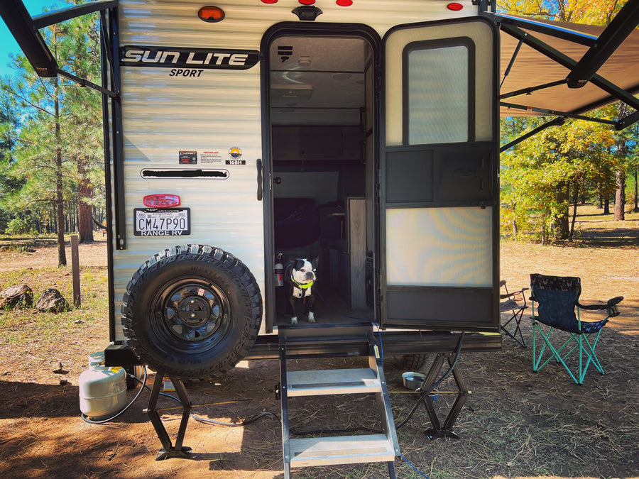 A cozy Sun Lite Sport 16BH **rv rental**, perfect for pet-friendly camping adventures, with a Boston Terrier on guard.