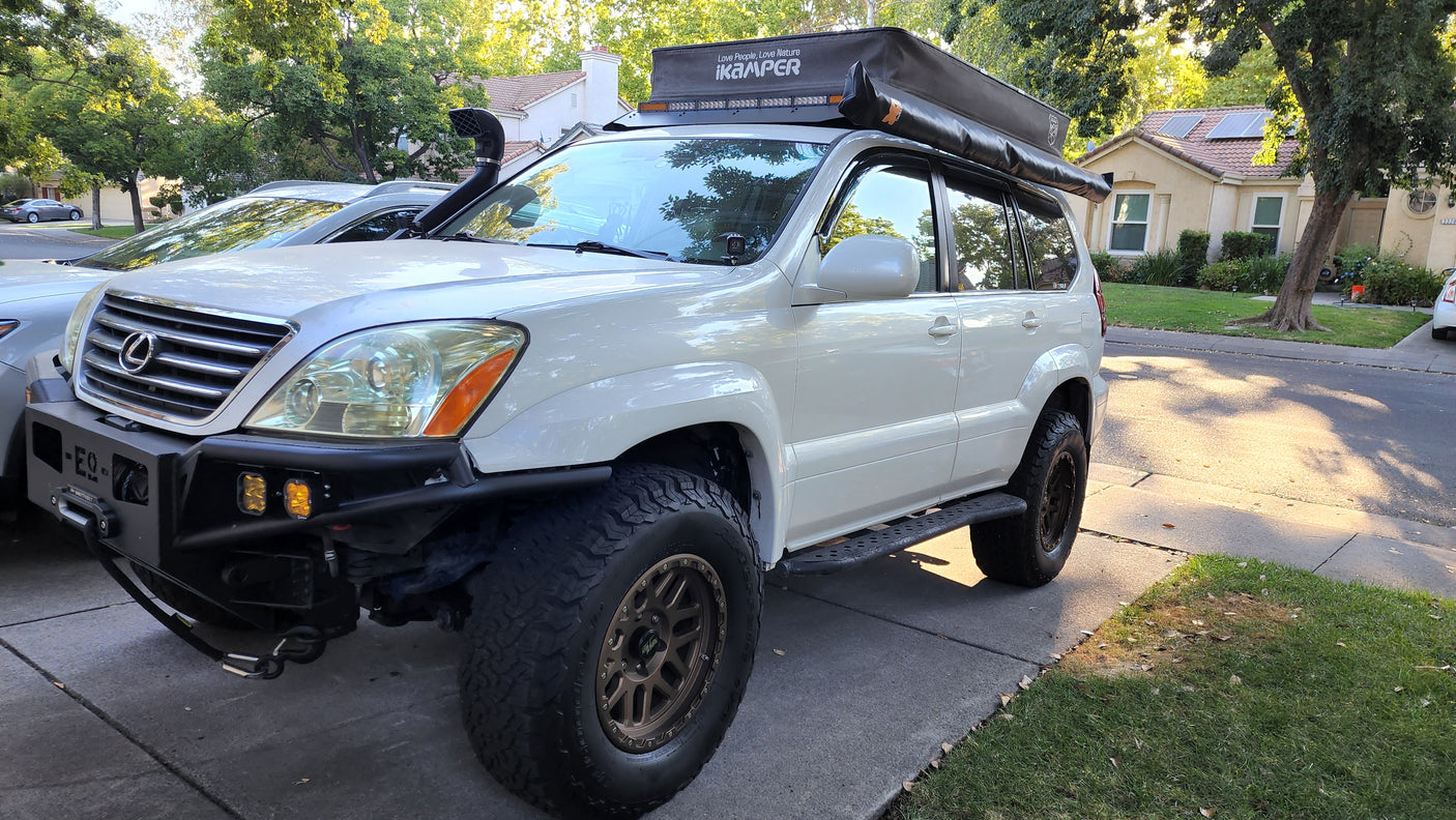 White Lexus GX SUV with iKamper rooftop tent, ready for an overlanding rv rental adventure.