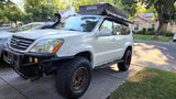 White Lexus GX SUV with iKamper rooftop tent, ready for an overlanding rv rental adventure.