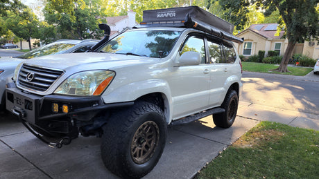 White Lexus GX SUV with iKamper rooftop tent, ready for an overlanding rv rental adventure.