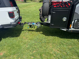 White Jeep truck hitched to an off-road trailer with a bike rack. Ideal setup for an RV rental adventure.