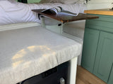  and the open road visible through the windshield.|Modern rv rental van conversion interior: comfy bed