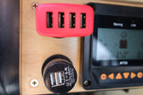 Inside an RV rental, a red 4-port USB hub, 12V dual charger, and MT50 solar controller display show power status.