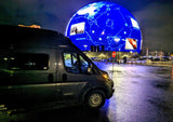 Night view of an RV rental in Las Vegas with The Sphere displaying "TARGET DETECTED." Unique travel experience.